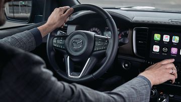 Mazda BT-50 2024 sở hữu cụm vô lăng 3 chấu bọc da (2 bản cao cấp) hỗ trợ điều chỉnh 4 hướng và đầy đủ các phím điều khiển chức năng