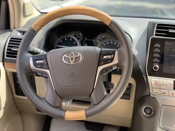 Toyota Prado 2023 sở hữu vô lăng bọc da dạng 4 chấu độc đáo, được nhấn nhá bởi các chi tiết ốp gỗ, mạ chrome vô cùng sang trọng