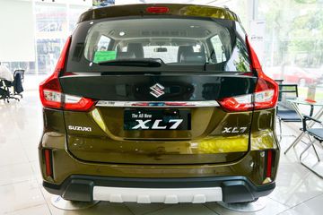 Suzuki XL7 2023 gắn logo chữ S đầy nổi bật tại khu vực dưới kính sau, đặt trên nền nước sơn đen bóng đồng màu với viền kính