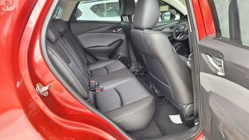 Hàng ghế thứ 2 trên Mazda CX-3 chỉ ở mức đủ dùng, có đầy đủ tựa đầu 3 vị trí và bệ để tay trung tâm tích hợp đựng cốc trong ghế giữa