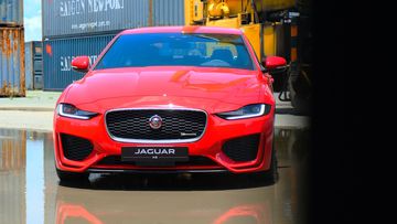 Jaguar XE 2024 sở hữu bộ lưới tản nhiệt dạng mắt lưới bậc thang khá thon gọn cùng những đường gân dập nổi mạnh mẽ trên nắp capo