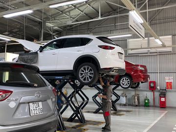 Nhân viên kỹ thuật đang kiểm tra gầm xe tại khu bảo dưỡng