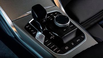 Khu vực điều khiển trung tâm giữa hàng ghế trước BMW 4 Series 2023 gọn gàng và tinh tế